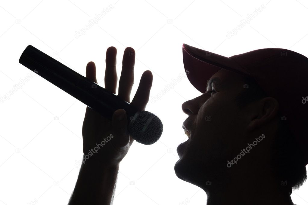 Young man in cap singing into a microphone