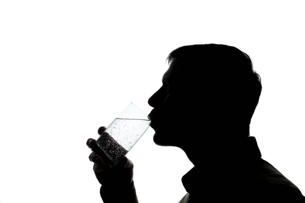 Young man drinks soda water - silhouette — Stock Photo, Image