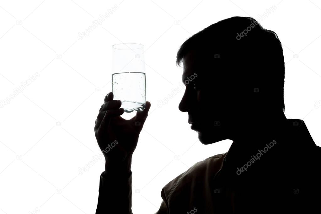 Young man drinks, checks the quality of soda water - silhouette