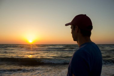 Plaj - gündoğumu şapkalı genç bir adam portresi