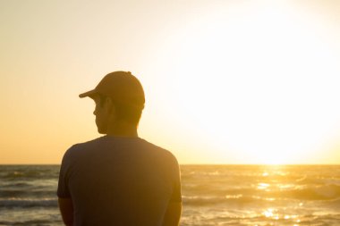 Plaj - gündoğumu şapkalı genç bir adam portresi