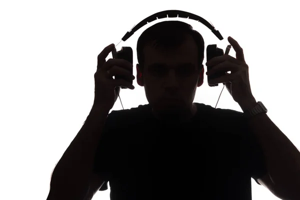 Silhouette of a young man with a smartphone with headphones — Stock Photo, Image