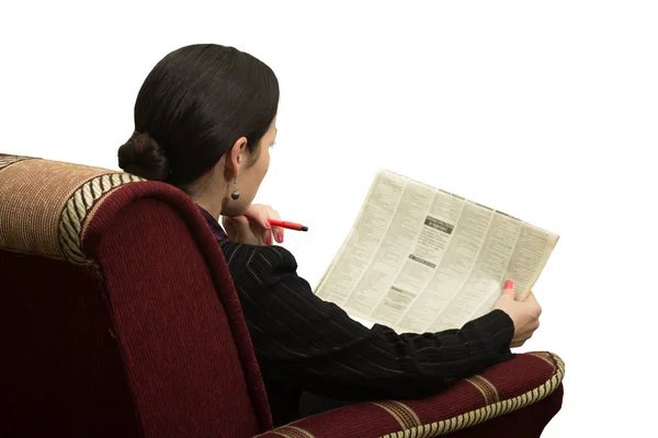 Mujer joven en silla leyendo un periódico con un anuncio — Foto de Stock