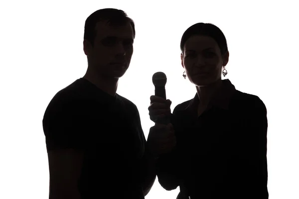 Young man and woman singing into the microphone — Stock Photo, Image