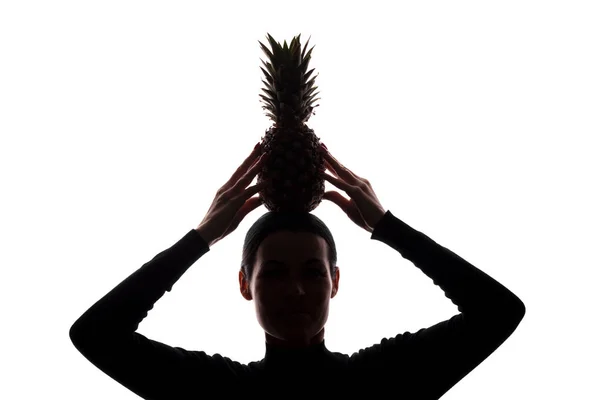 Pineapple in a woman's hands above the head - silhouette — Stock Photo, Image