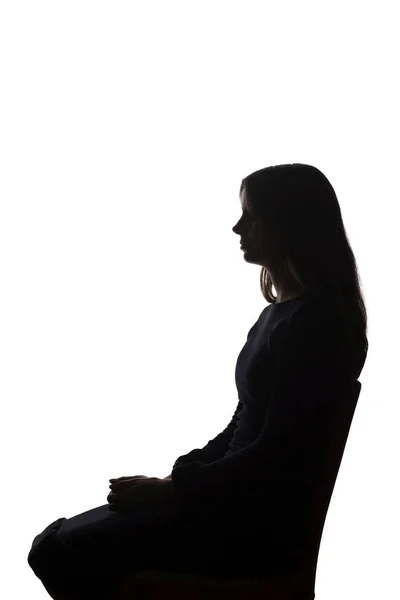 Menina bonita sentada em uma cadeira silhueta, isolar — Fotografia de Stock