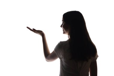 Genç kadın işaret parmağını gösteriyor, elini öne doğru
