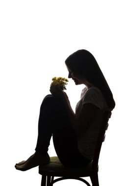 Elinde çiçek konsepti ve sembolü olan güzel bir genç kızın portresi. Siluet, izole edilmiş.