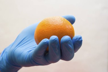 Tıbbi bir eldiven, ilaç, koronavirüs ve kovid19 yerine bağışıklık için vitamin içeren bir portakal içerir.