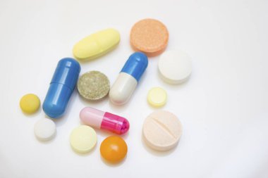 Beyaz bir zemin üzerinde birçok tablet ve kapsül - karantina sırasında gribe karşı koruma, koronavirüs, covid19