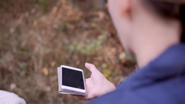 Chica escribiendo en su teléfono inteligente en el bosque — Vídeo de stock