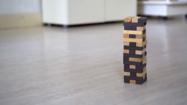 Hand destroying Jenga Tower in the room — Stock video