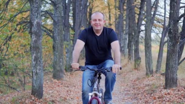 Man cyclist to riding a bicycle in the autumn forest — Stock Video