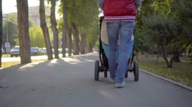 Anne ile çocuk arabası Park yürüme. Sonbahar doğa arka plan. Alt görünümü. Stedycam.
