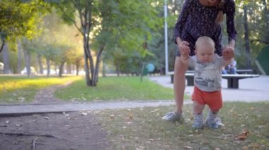 İlk adım çocuk yapar, annesi ona yardım et. Sonbahar park.