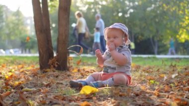 Bebek ormanın içinde. Düşen sonbahar yaprakları. Ağır çekim 100 fps.
