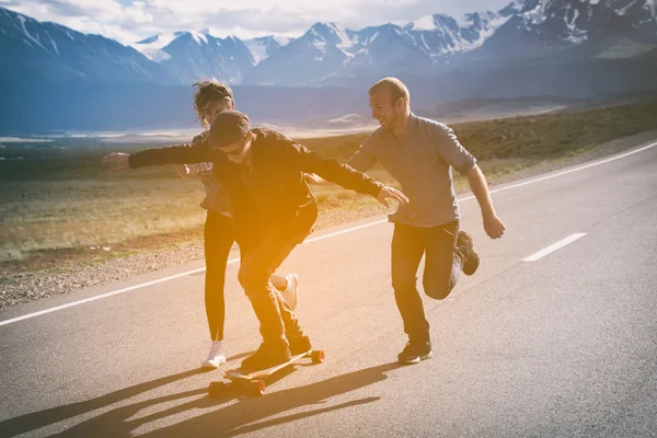 Arkadaş grubu koş, kahkaha ve sahip eğlenceli. Adam longboard üzerinde.