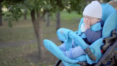 Bebek çocuk arabası içinde uyumak istiyor ve gözleri losyonları.