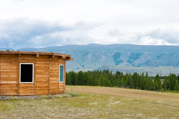 Fából készült hegyi ház zöld mező. Hegyek, Altay, Oroszország. — Stock Fotó