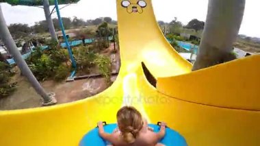 Mutlu bir adam ve kadın su kaydırağı sürme. Yaz tatili sırasında su Park resort doğum eğleniyor insanlar