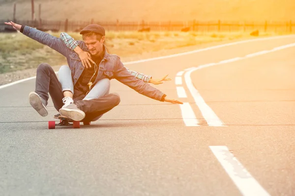 Kız sürücünün bir dağ yolda longboard adamla. Kadın kucaklama adam. Ellerini farklı yönlere ayrılmış.