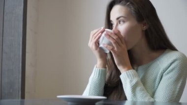 Güzel kız bir masada oturan ve çay içme. Rahatlatıcı.