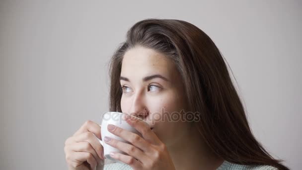 Krásná dívka pití čaje nera okna. Portrét detail. — Stock video