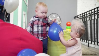 İki bebek, erkek ve kız oyuncakları ile birlikte parkta oynarken,.