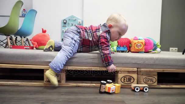Маленький милый мальчик играет дома с игрушечной машиной . — стоковое видео