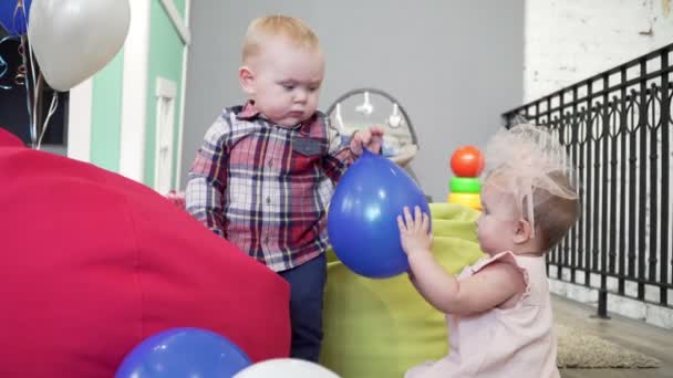 Dos bebés, niño y niña, jugando juntos con juguetes en el patio de recreo . — Vídeos de Stock