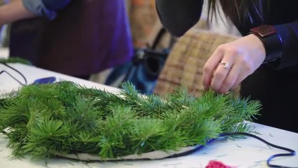 Criando uma coroa de Natal com decorações. Close-up . — Vídeo de Stock