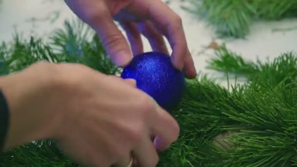 Het creëren van een kroon van Kerstmis met decoraties. Close-up. — Stockvideo