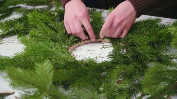 Creazione di una corona di Natale con decorazioni. Primo piano . — Video Stock