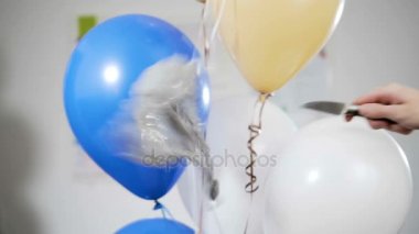 El bir bıçakla balonlar delip geçiyor ve uzak üflenir ve patlayabilir. Ağır çekim.