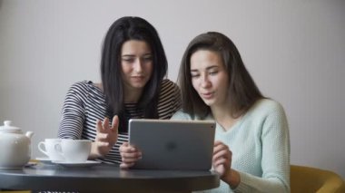 Bir tablet Pc ve gülmek kafede oturan iki güzel kız arıyor. Kamera casus.
