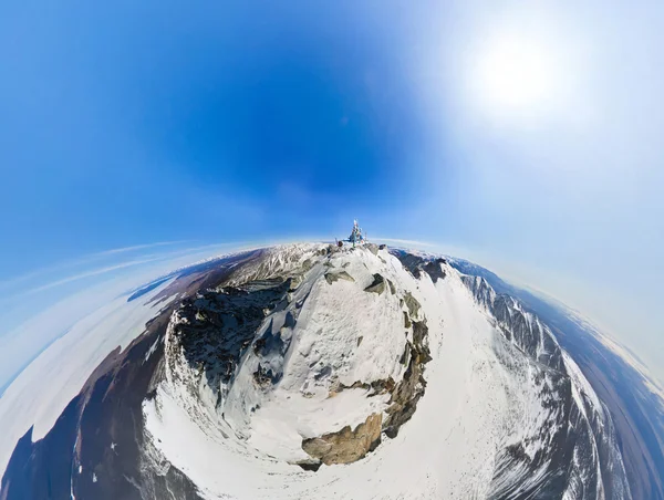 Rilevamento aereo sulla cima di una montagna innevata in una giornata di sole al — Foto Stock