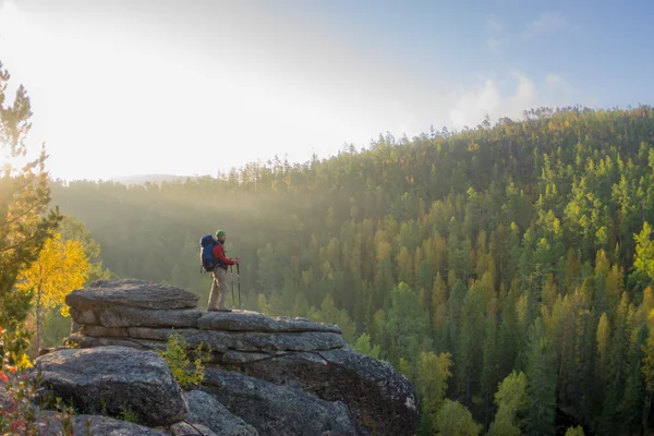 Omul cu rucsac și trekking pol în bandana în picioare pe un roc — Fotografie, imagine de stoc