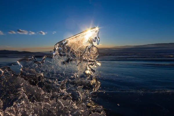 Sun at sunset shining through the transparent texture of the ice — Stock Photo, Image