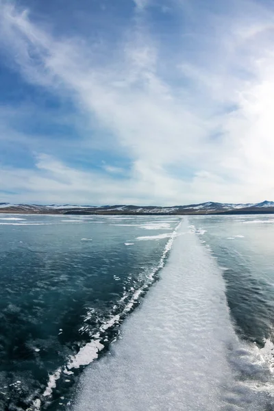 El camino de las grandes grietas blancas en el hielo del lago Baikal . — Foto de Stock