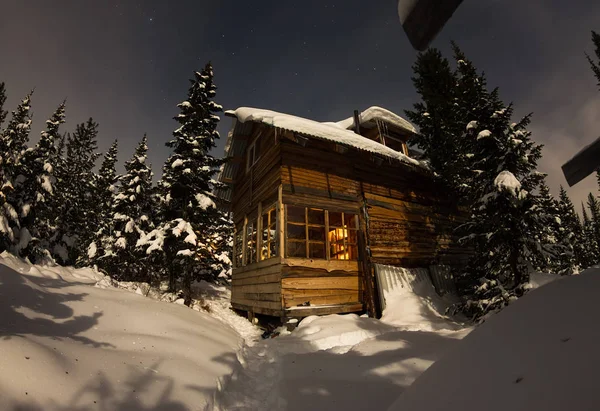 Maison Chalet lors d'une chute de neige dans les arbres forêt d'hiver à nig — Photo