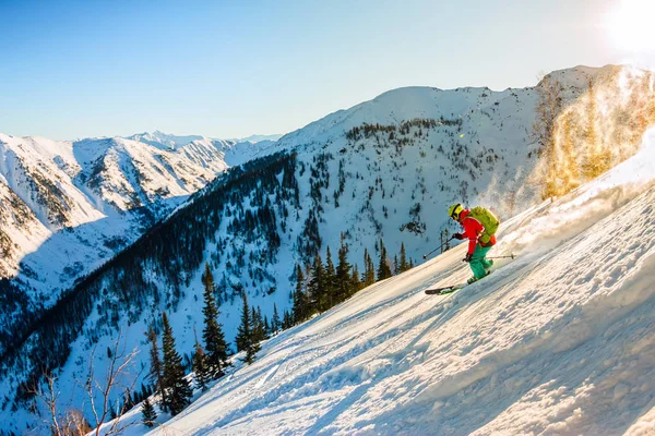Freerider esquiador desciende de la montaña en la luz — Foto de Stock