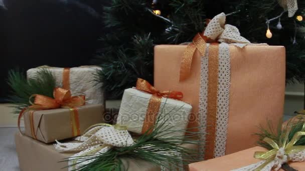 Regalos presenta cajas bajo abeto navideño decorado con juguetes y guirnalda guiñada blanca. Movimiento de cámara deslizante . — Vídeos de Stock