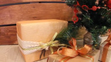 Hediyeler oyuncak ve beyaz ışık garland göz kırpıyor ile dekore edilmiş Noel köknar ağacı altındaki kutuları sunar. Slayt kamera hareketi.