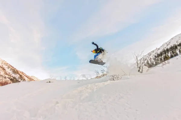 Freerider está saltando en el rocío de nieve desde la pendiente —  Fotos de Stock