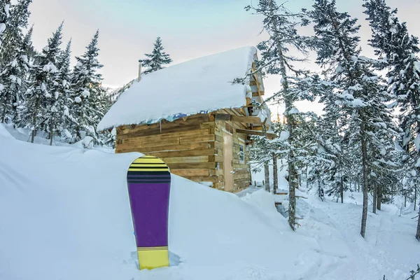 Snowboard à la maison chalets en forêt d'hiver avec neige en mountai — Photo