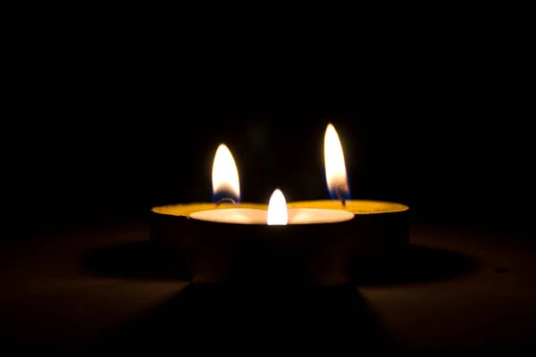 Small round candle burning in the dark tablet — Stock Photo, Image