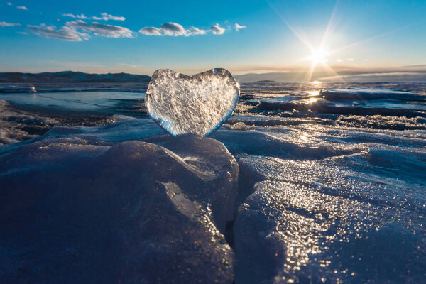 Icy heart in the waves in the light of sunset. lake Baikal