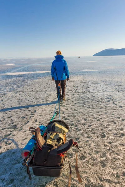 Ragazza con una slitta e bastone da trekking è sul ghiaccio del lago di Baika — Foto Stock