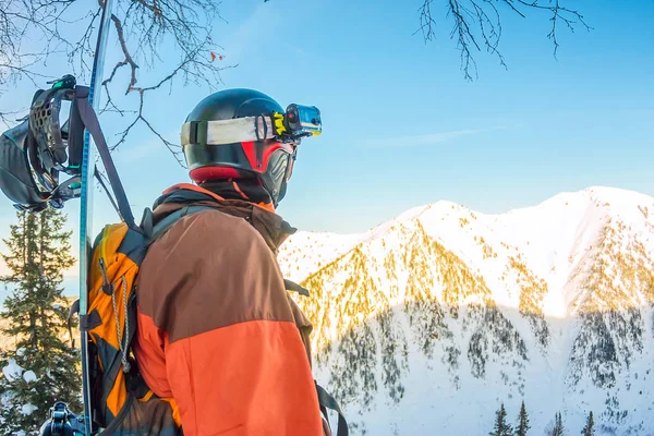 Freerider uomo è in piedi sul fianco della montagna in un casco e wi — Foto Stock