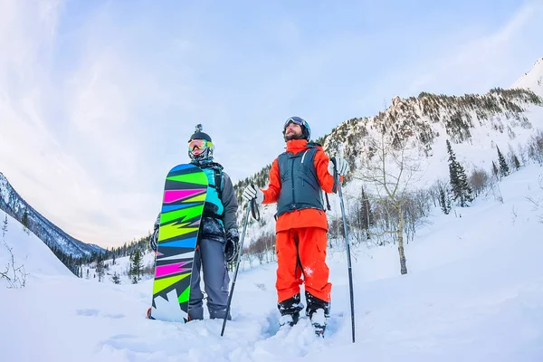 Fani freeride mężczyzna narciarze i snowboardziści są w górach, w — Zdjęcie stockowe